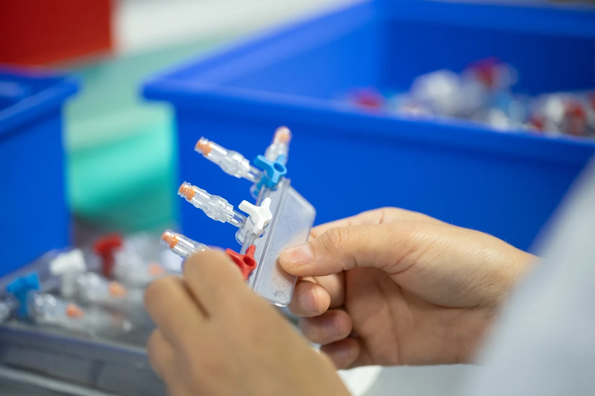 Mitarbeiter montiert medizinische Verbindungsbauteile